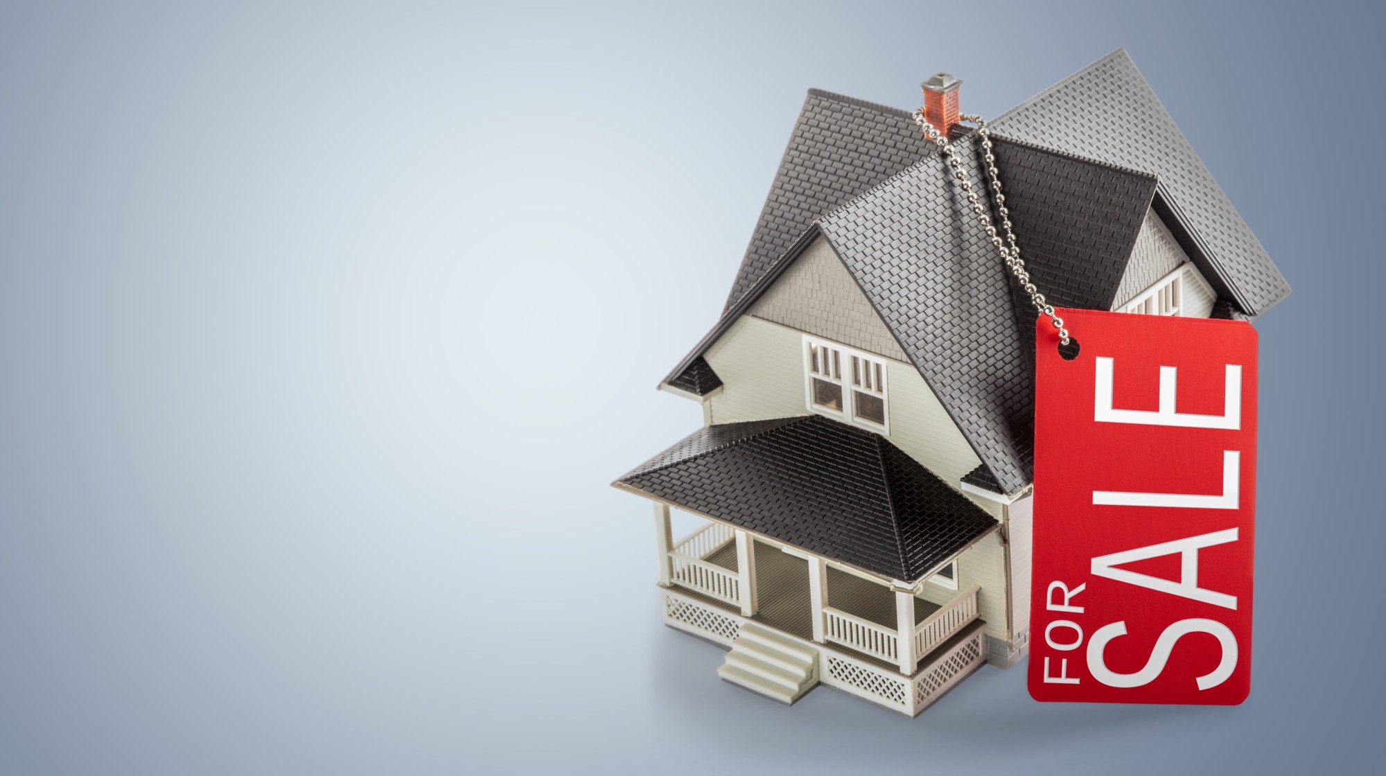 Image of a house with a sale tag.